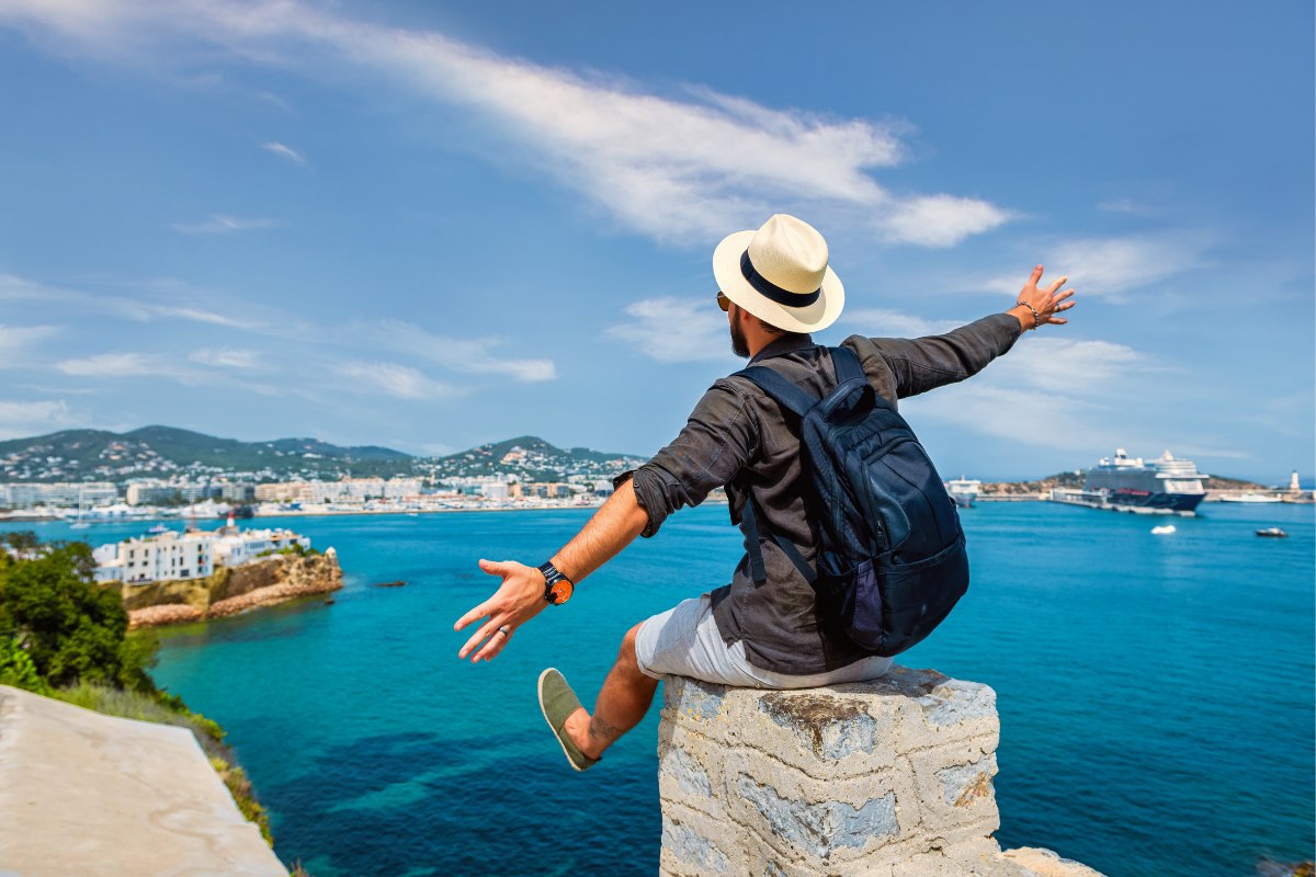 Travel brand campaign creative showing a traveller at a coastal destination